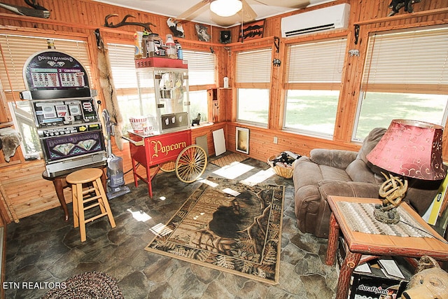 living room featuring ceiling fan, wooden walls, plenty of natural light, and a wall mounted air conditioner