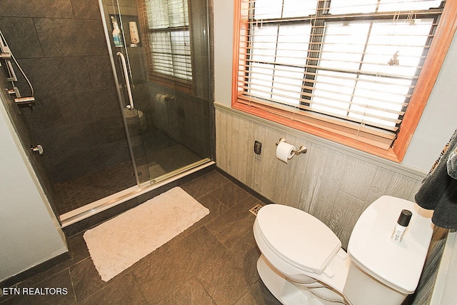 bathroom with wood walls, an enclosed shower, and toilet