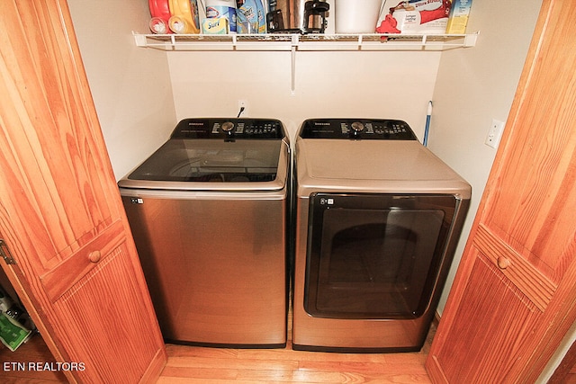 laundry room with light hardwood / wood-style floors and washer and dryer