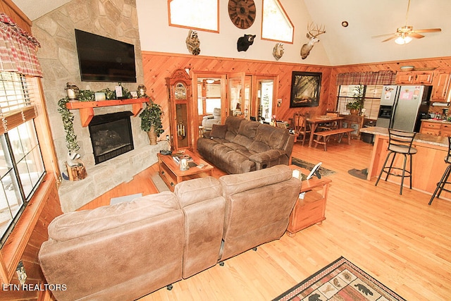 living room with light wood-type flooring, a healthy amount of sunlight, a fireplace, and ceiling fan