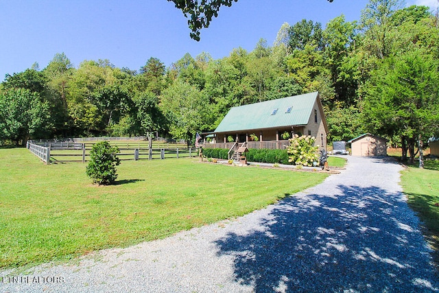 exterior space featuring a front yard, a rural view, and a storage unit