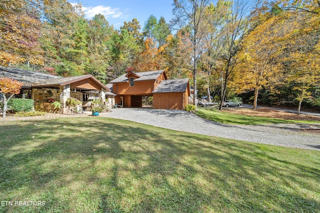 view of front of home with an outdoor structure, a front yard, and a carport