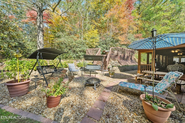 view of patio featuring a deck and an outdoor fire pit