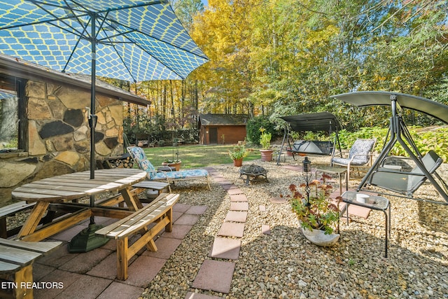 view of patio / terrace featuring a fire pit and a storage unit