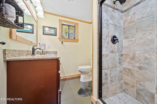 bathroom with tile patterned floors, a shower with door, vanity, and toilet