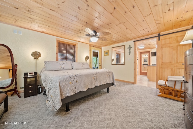 carpeted bedroom with a barn door, ceiling fan, wood ceiling, and ornamental molding