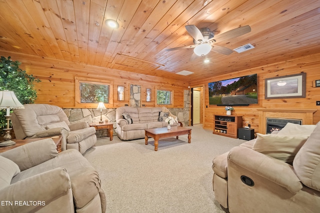 living room with ceiling fan, wood ceiling, carpet floors, and wooden walls