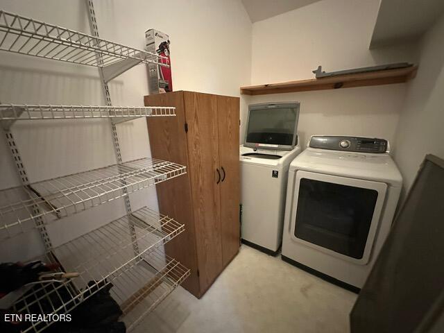 laundry room with washer and clothes dryer and light carpet