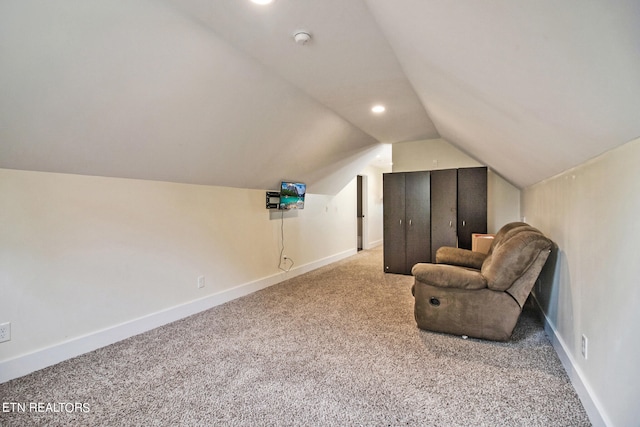 sitting room featuring light carpet and lofted ceiling