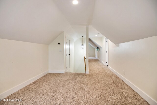 bonus room featuring vaulted ceiling and light colored carpet