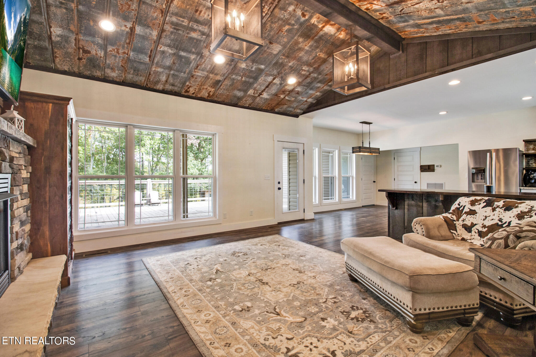 living room featuring a fireplace, beam ceiling, dark hardwood / wood-style floors, and high vaulted ceiling