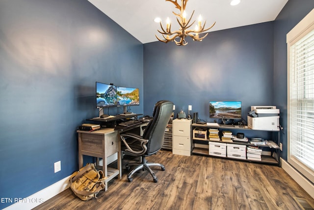 office space featuring wood-type flooring, an inviting chandelier, and lofted ceiling