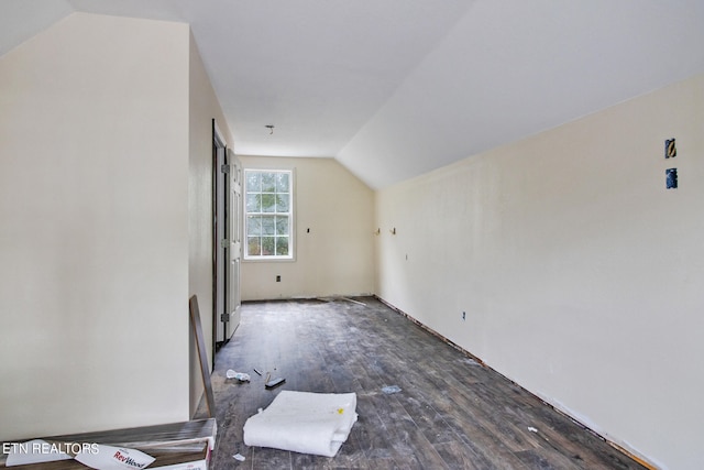 additional living space featuring lofted ceiling and dark wood-type flooring