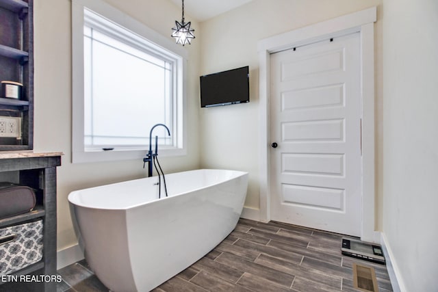 bathroom featuring wood-type flooring, a bath, and vanity