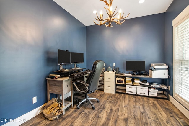 home office with an inviting chandelier, lofted ceiling, and hardwood / wood-style flooring