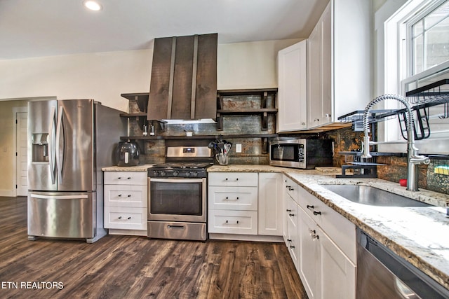 kitchen with light stone counters, sink, white cabinetry, stainless steel appliances, and dark hardwood / wood-style floors