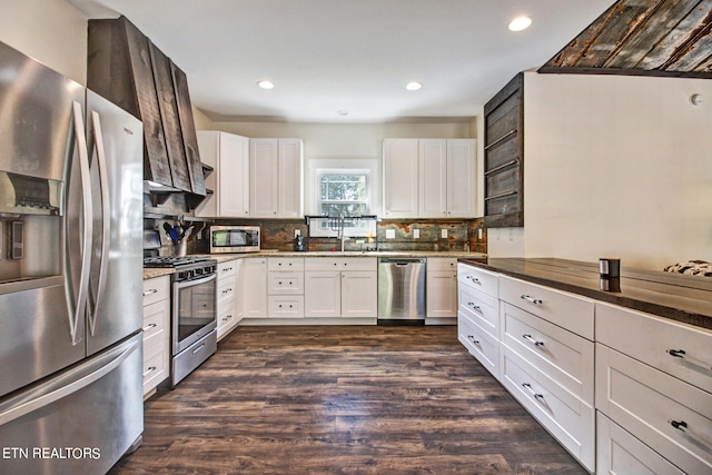 kitchen featuring white cabinets, stainless steel appliances, backsplash, and dark hardwood / wood-style flooring