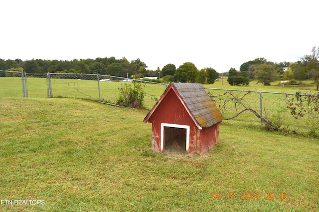 view of outbuilding with a rural view and a yard