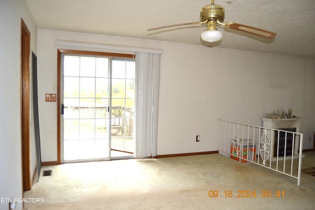 carpeted spare room featuring ceiling fan