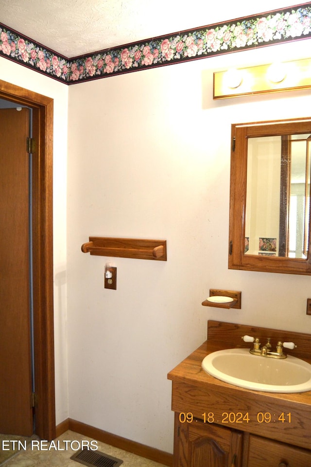 bathroom with a textured ceiling and vanity