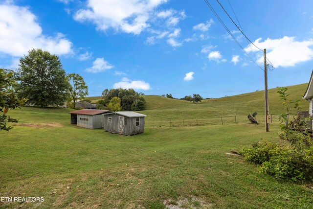 view of yard with a shed and a rural view