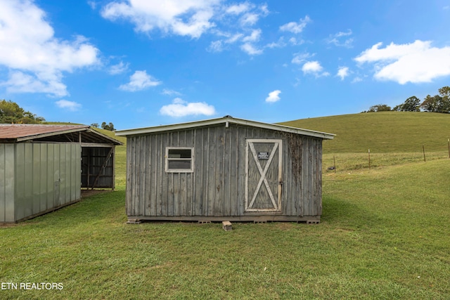 view of outbuilding with a yard and a rural view