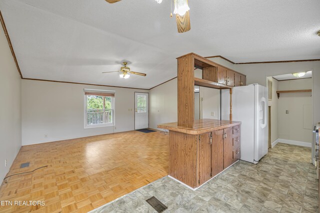 kitchen featuring a textured ceiling, white refrigerator with ice dispenser, vaulted ceiling, light parquet flooring, and ceiling fan