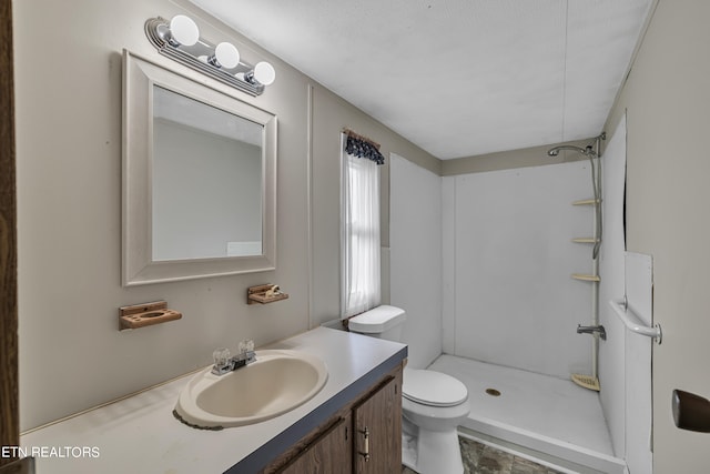 bathroom featuring walk in shower, vanity, and toilet