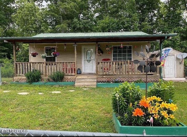 bungalow featuring covered porch, a front lawn, and a shed