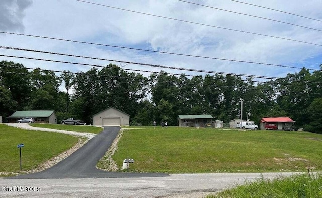 view of front facade featuring an outdoor structure, a garage, and a front yard