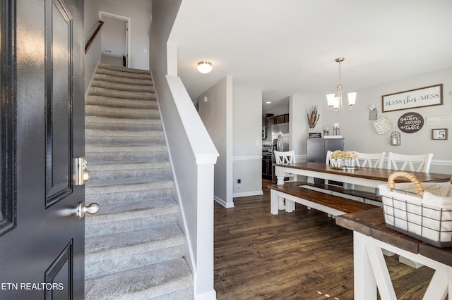 staircase with a chandelier and hardwood / wood-style floors