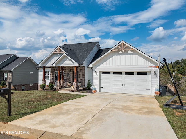 craftsman house featuring a front yard, central air condition unit, and a garage