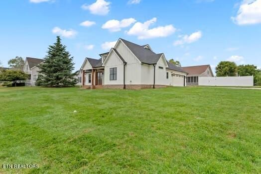 rear view of house featuring a yard