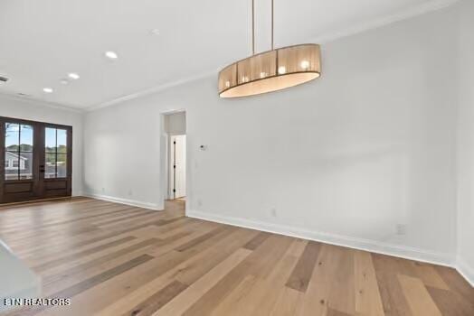 spare room featuring hardwood / wood-style flooring, french doors, and ornamental molding