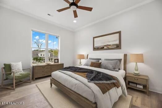 bedroom with ceiling fan, crown molding, and light wood-type flooring