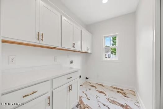 washroom featuring hookup for an electric dryer and cabinets