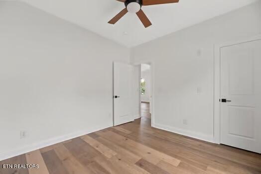 empty room with hardwood / wood-style flooring and ceiling fan