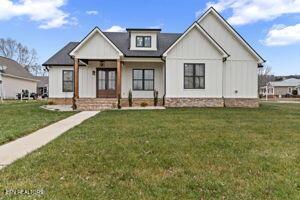 modern farmhouse style home with a front lawn