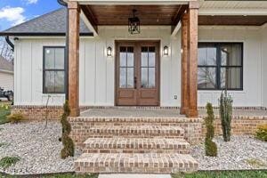 property entrance featuring covered porch and french doors