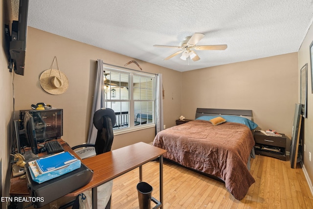 bedroom with ceiling fan, a textured ceiling, and light hardwood / wood-style floors