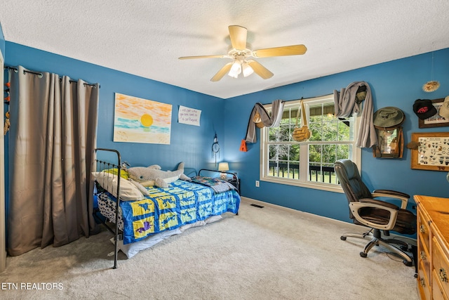 carpeted bedroom featuring ceiling fan and a textured ceiling