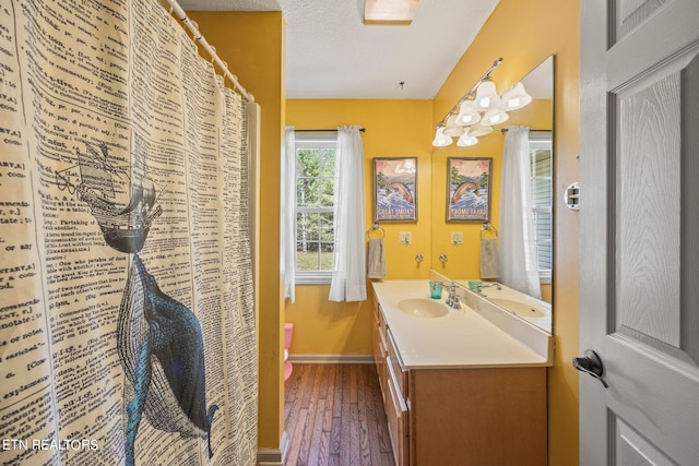 bathroom featuring a textured ceiling, toilet, vanity, and hardwood / wood-style floors