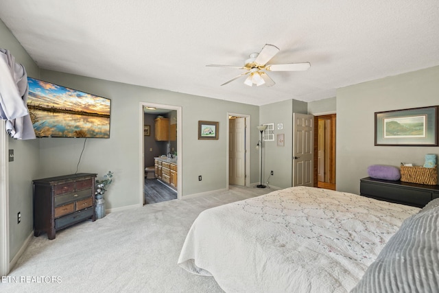 carpeted bedroom featuring a textured ceiling, ensuite bath, and ceiling fan