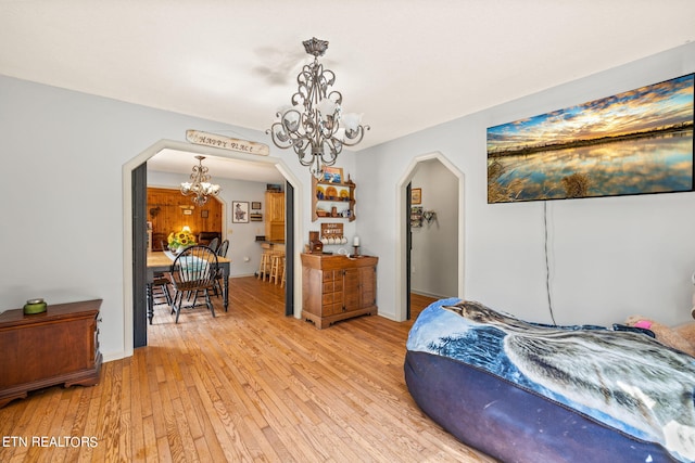 bedroom featuring light wood-type flooring and a chandelier