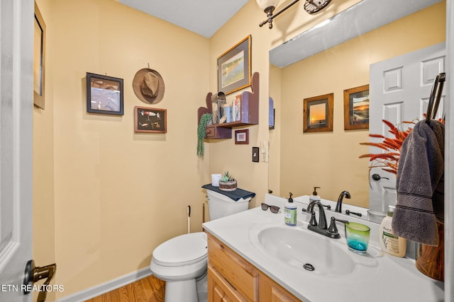 bathroom featuring wood-type flooring, vanity, and toilet