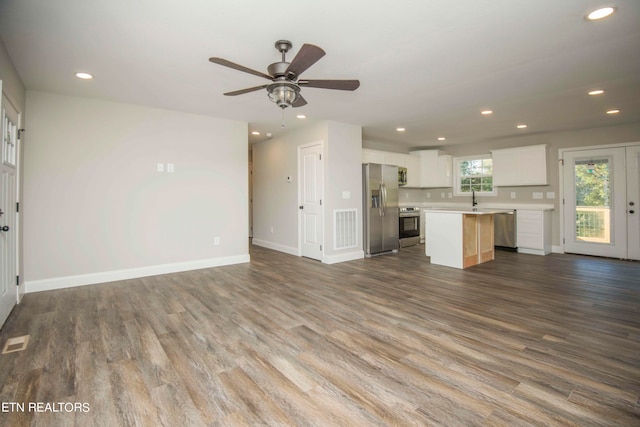 unfurnished living room featuring ceiling fan, hardwood / wood-style flooring, and sink