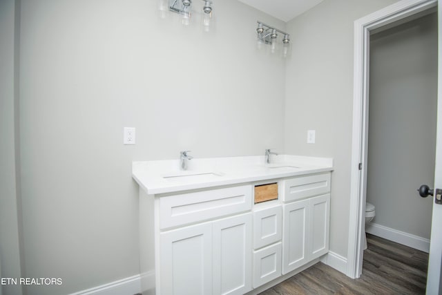 bathroom featuring wood-type flooring, vanity, and toilet