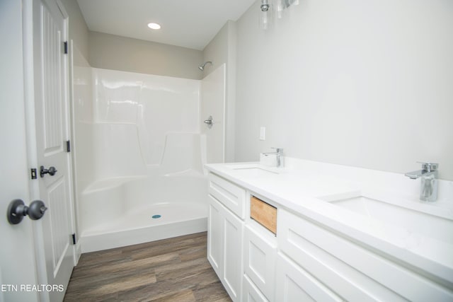 bathroom featuring walk in shower, wood-type flooring, and vanity