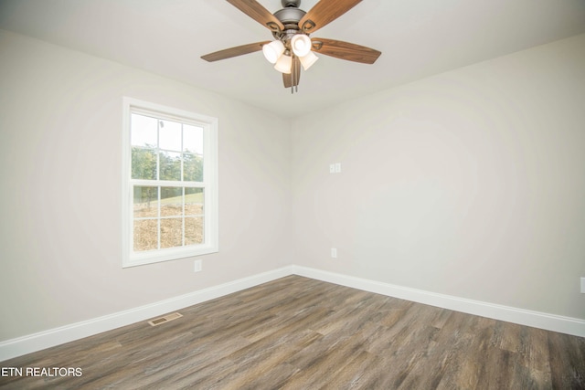 empty room with dark hardwood / wood-style flooring and ceiling fan