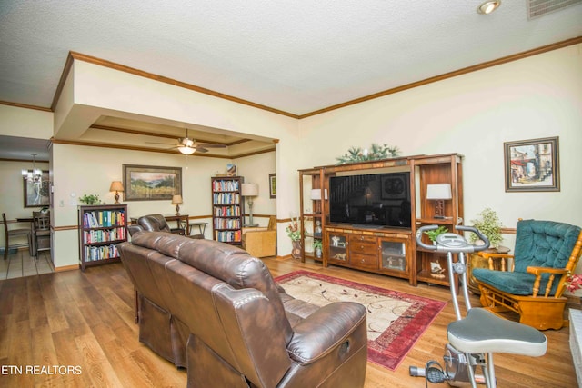 living room featuring ceiling fan, hardwood / wood-style flooring, and a textured ceiling